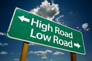 highway sign that points to high road in one direction and low road in the opposite direction